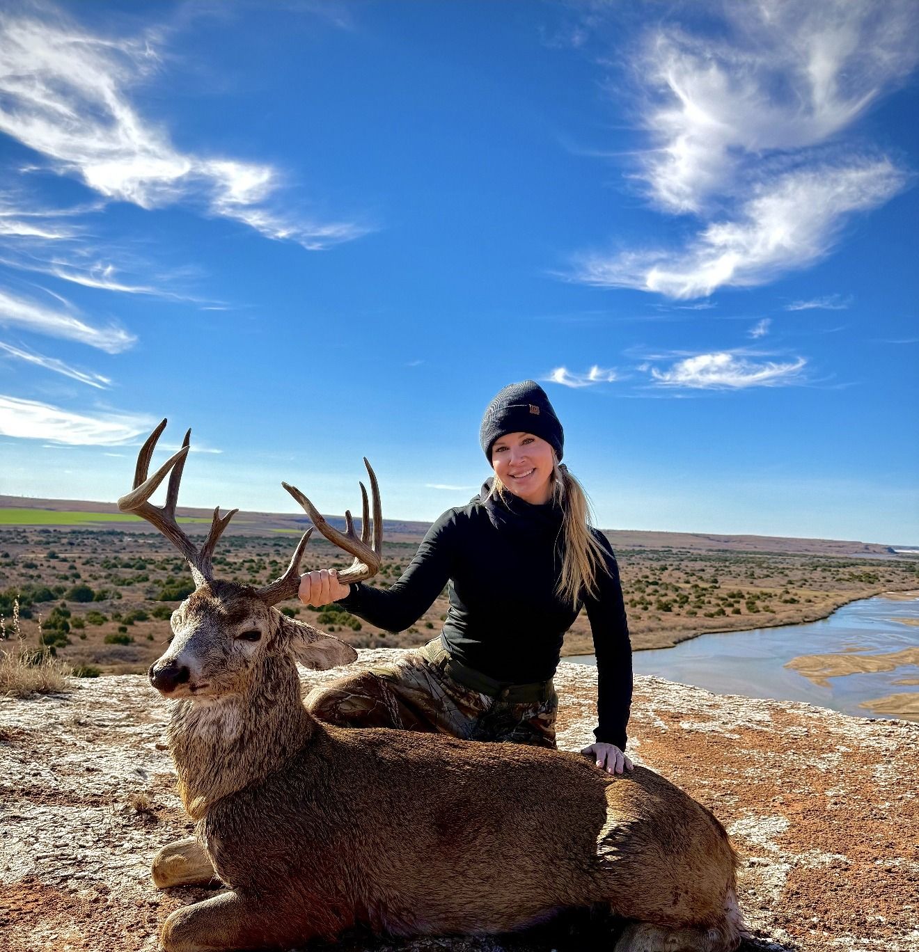 A hunter with a mature whitetail on a bluff above the river in northwest Oklahoma