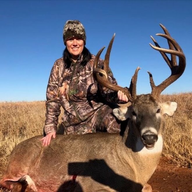 Hunter with a heavy-racked Oklahoma whitetail on native prairie